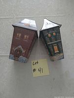 Front view of two house-shaped tins standing upright