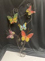 Full view of metal wall art showing five butterflies, vine and leaves