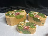 All three octagon boxes with lids showing lotus artwork