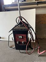 Full view of metal battery charger with handle and cables