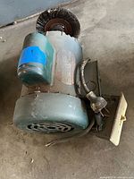 Overall view of Dayton bench grinder showing motor housing, wire brush wheel and power cord