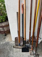 Group of garden tools showing shovel, edger, hoe, rake and pick heads