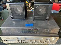 Stereo receiver with two speakers resting on dust cover