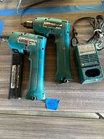 Two Makita cordless drills, charger, stick battery