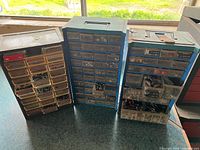 Front view of three multi-drawer storage cabinets with visible contents