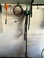 Overview showing chain hoist, pipe threader and drain auger on wall