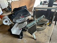 Overall view of Craftsman miter saw and metal miter box on workbench