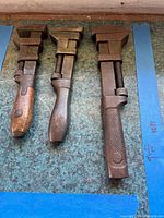 Three vintage adjustable monkey wrenches aligned side by side