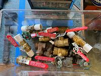 Clear bin showing assorted brass and bronze valves