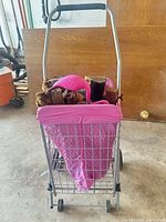 Rear view of metal cart with pink liner holding wood and flamingo