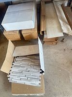 Overview of boxes containing porcelain plank tiles and mosaic panels