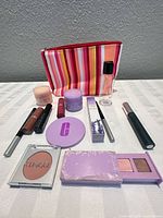 Full lot showing 14 Clinique items laid out with striped pouch and travel bottle