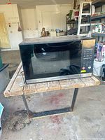 Front view of Cuisinart microwave showing black and stainless finish and door window