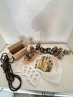 Group view of assorted door hardware, hinges, knobs, plates, rope