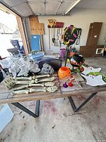 overall lot on table showing skeleton bones, ghosts, tombstone sign, prize wheel, cauldron, candy bucket, goblets
