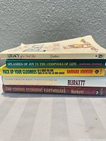 Stack of five hardcover books showing titles and authors