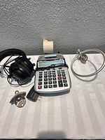 All four items grouped: Razer headset, Canon calculator with paper roll and adapter, Coca-Cola opener, nickel towel ring