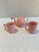 Teapot centered with two matching mugs