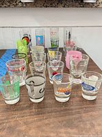 Front view of assorted clear, frosted and plastic logo shot glasses