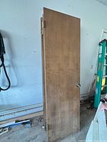 Stacked brown hollow core doors leaning against wall