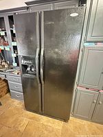 Full front view of Whirlpool black side-by-side refrigerator