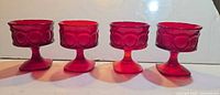 Four matching ruby red textured sherbet glasses with square bases