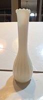 Full view of milk glass bud vase standing upright