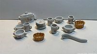 Full grouping of porcelain dishware, wicker baskets and spoon