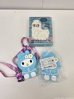 Boxed plush, opened silicone pouch with strap, sealed spare pouch