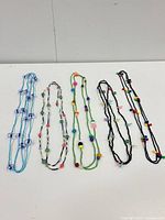 Front view of five bead necklaces laid out side by side