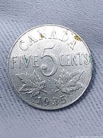 Reverse of 1935 Canadian five-cent coin showing CANADA, FIVE 5 CENTS, maple leaves, date 1935