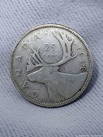 Reverse of 1938 Canadian quarter showing caribou and legends