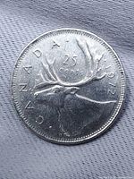 Reverse of 1972 Canadian quarter with caribou