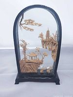 Front view of entire diorama showing carving, glass case and stand