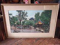Front view of framed woven picture showing garden and pagodas