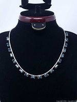 Necklace displayed on bust showing overall design with blue stones