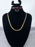 Full view of gold tone chain on display bust