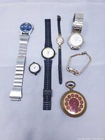 All seven watches laid out showing fronts and straps