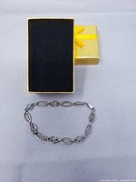 Bracelet laid out in front of gift box showing overall design