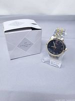 Watch on stand next to branded box