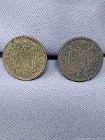 Both 1 peseta coins reverse side showing Spanish coat of arms and denomination