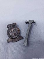 Front view of both pins showing inscriptions and hammer shape