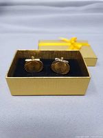 Both cufflinks in box showing sunburst faces