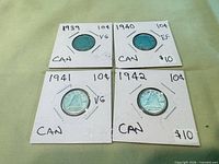 Overall view of four Canadian dimes in 2x2 holders