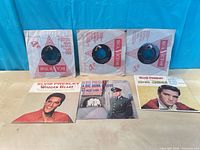 Group shot of all six Elvis Presley 45s showing three with picture sleeves and three in RCA Victor paper sleeves