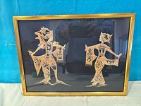 Front view of framed artwork showing two dancer cutouts on dark background