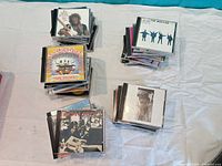 Four stacks of assorted CD albums visible