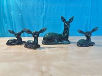 Front view of four drip-glaze ceramic deer figurines