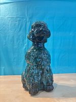 Front view of green-black drip-glaze ceramic poodle