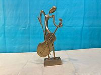 Front view of brass musician statue with cello